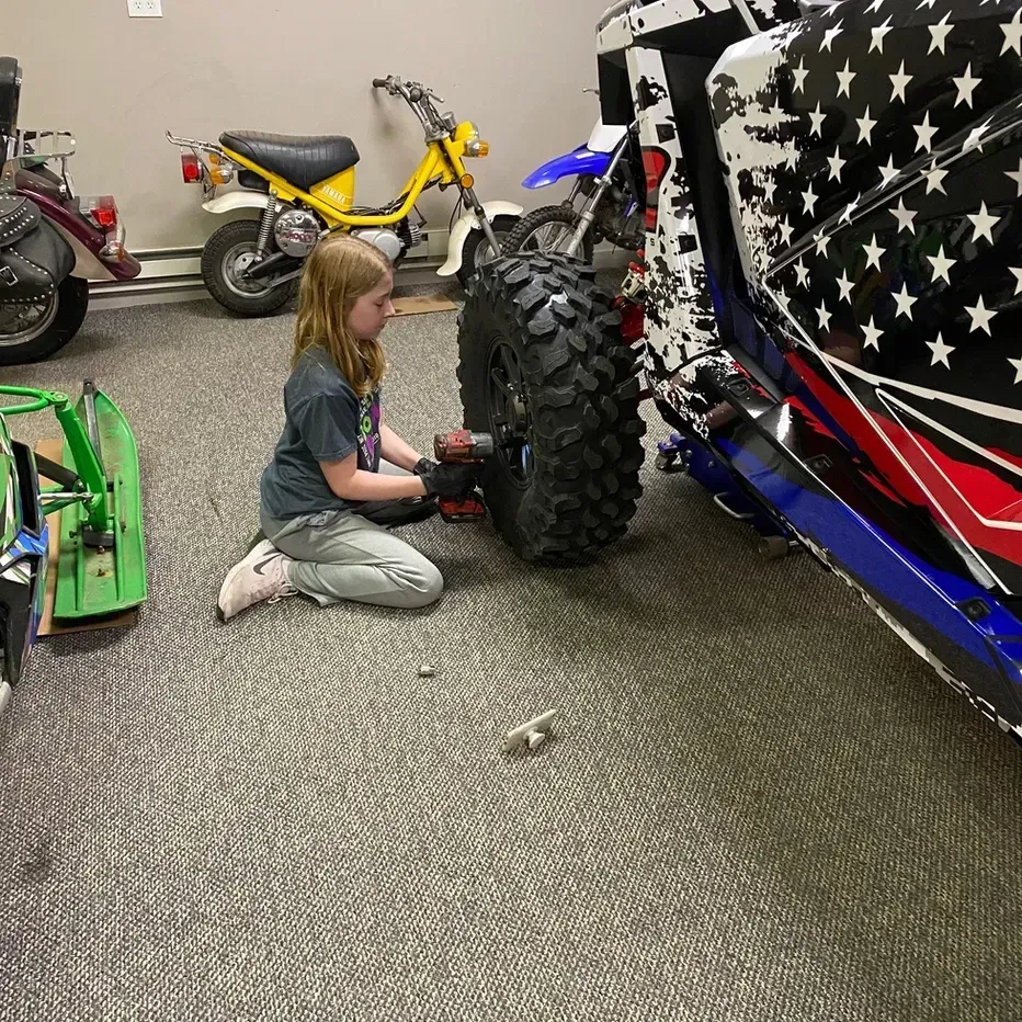 child working on atv
