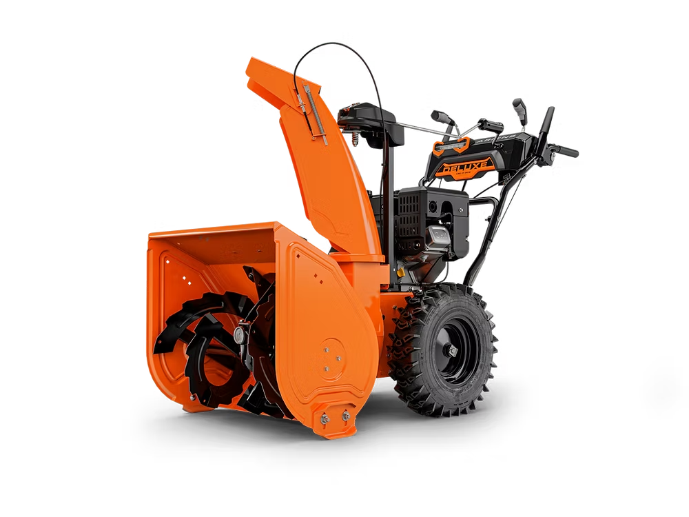 Orange snow blower on a white background, shown in side view with black wheels and handlebars
