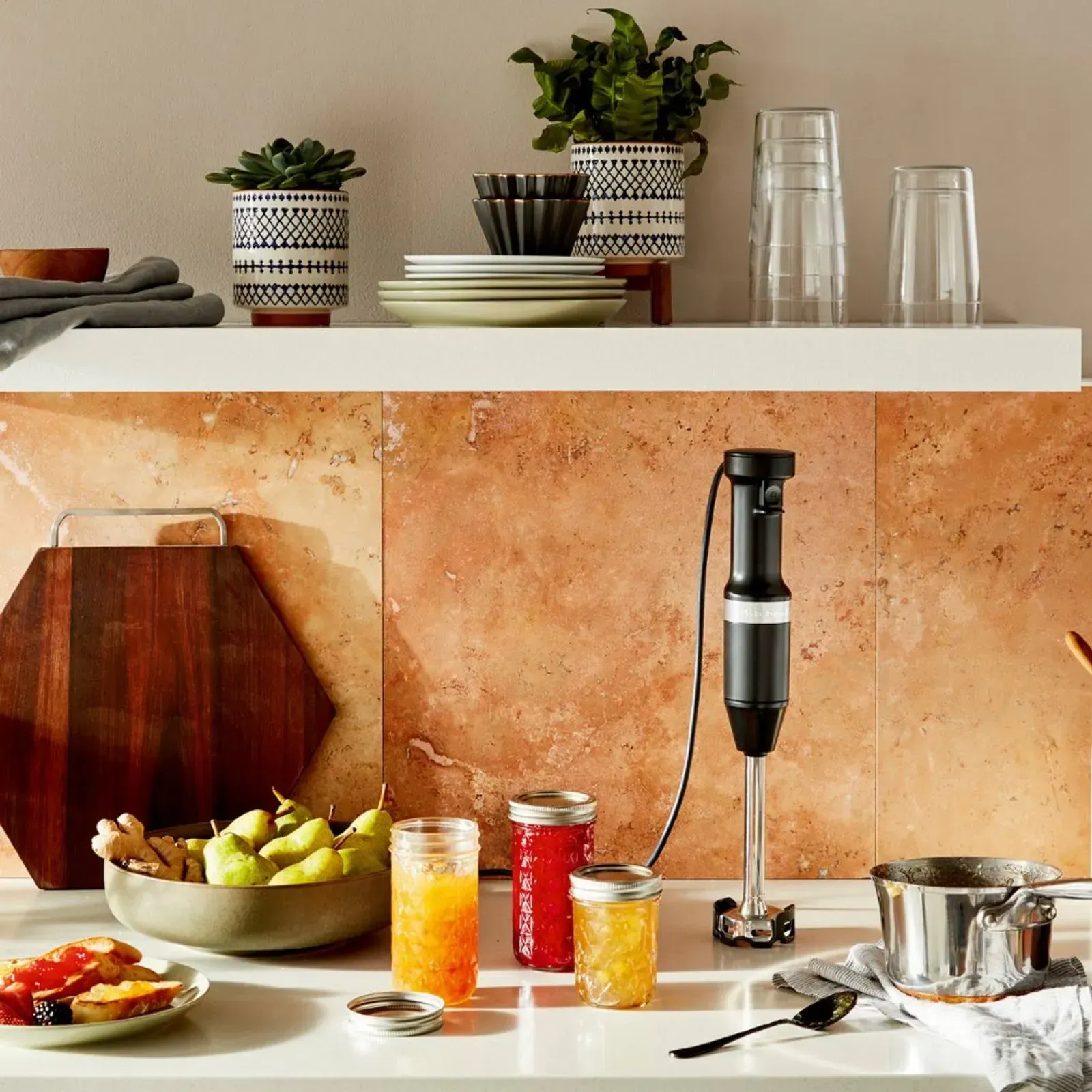 Um balcão de cozinha com um liquidificador e uma tigela de frutas