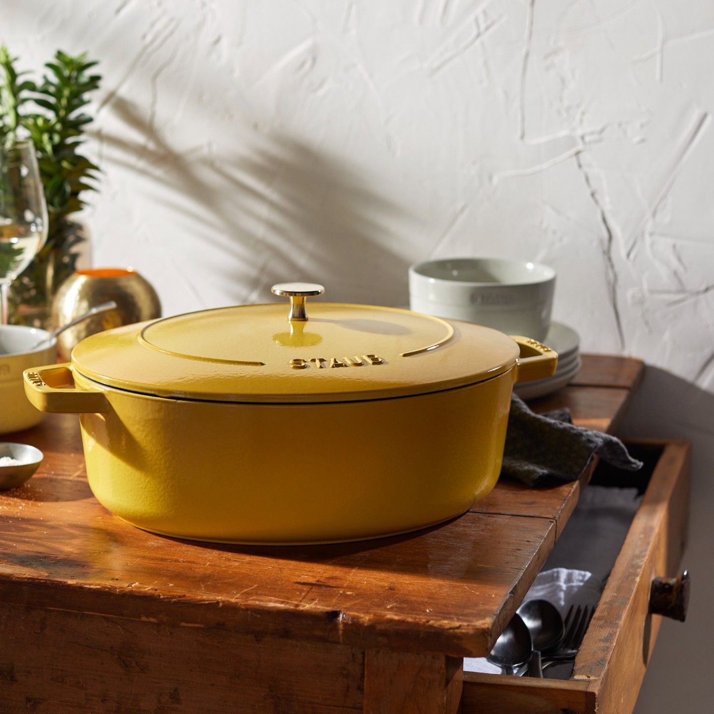 Um pote amarelo está sobre uma mesa de madeira