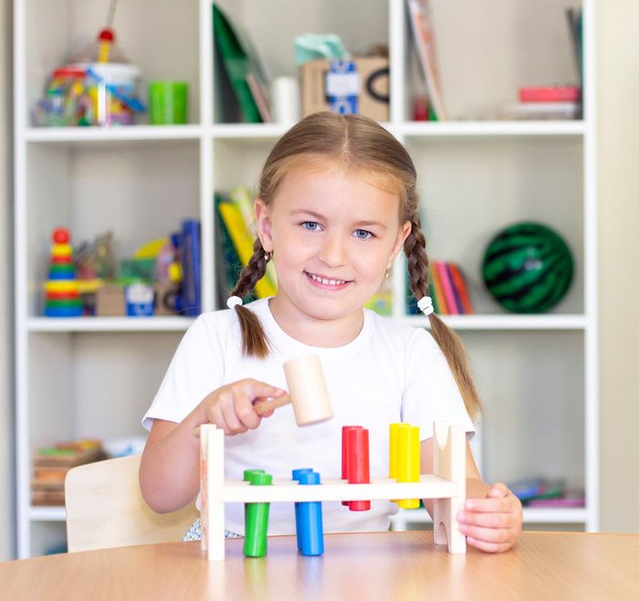 Girl Holding A Wood Hammer — Heckenberg, NSW — Step Ahead Child Care Centre Girl Holding A Wood Hammer — Heckenberg, NSW — Step Ahead Child Care Centre