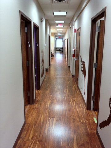 A long hallway with wooden floors and white walls at Advocare Washington Ave Pediatrics in Bergenfield, NJ