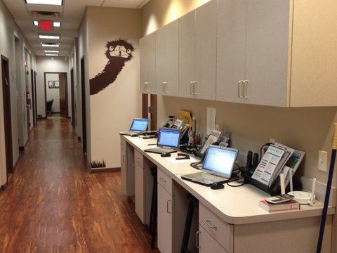 A row of desks with laptops on them in a hallway at Advocare Washington Ave Pediatrics in Bergenfield, NJ