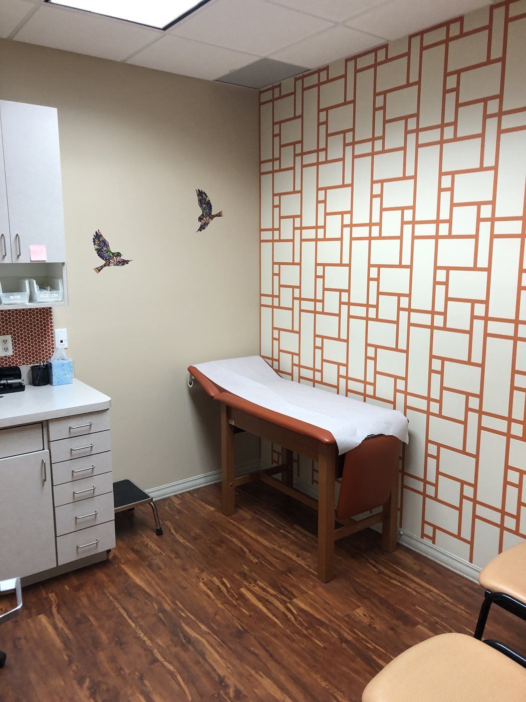 A doctor 's office with a table and chairs at Advocare Washington Ave Pediatrics in Bergenfield, NJ