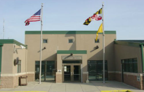 The front of a building with flags flying in front of it