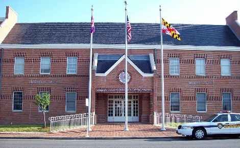 A police car is parked in front of a brick building