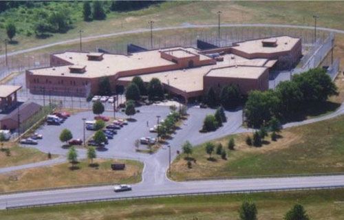 An aerial view of a large building with a lot of cars parked in front of it