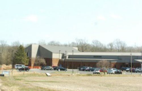 A large building with a lot of cars parked in front of it.