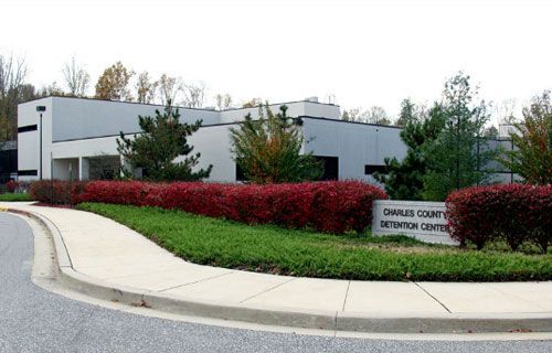 A white building with a sign that says charles county detention center