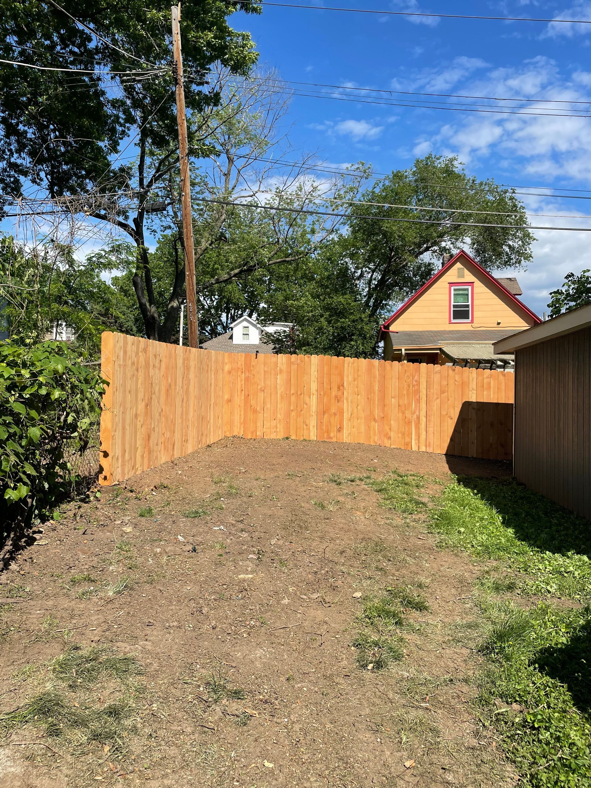 There is a wooden fence in the backyard of a house.