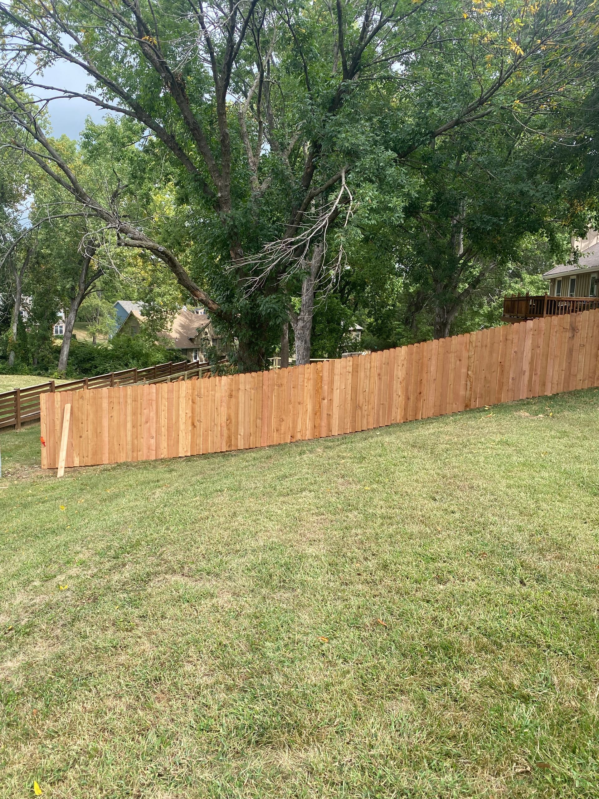 A wooden fence is sitting on top of a lush green lawn.