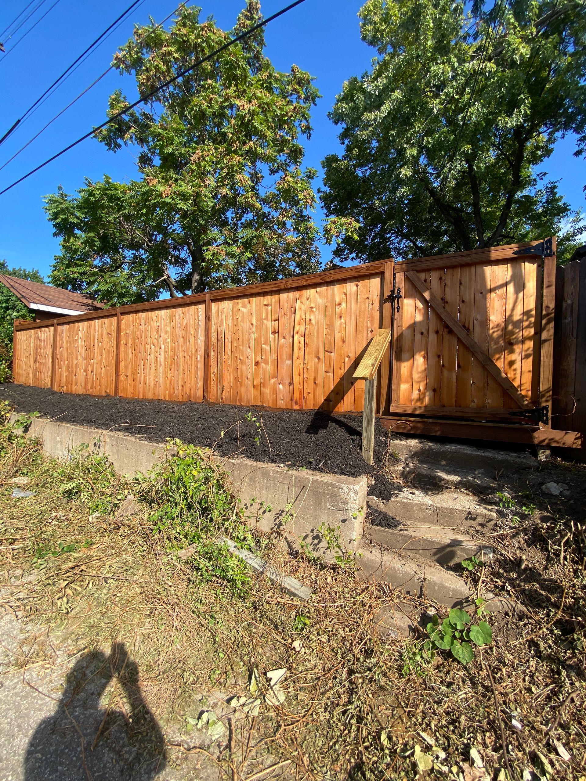 A wooden fence with a gate and stairs leading up to it.