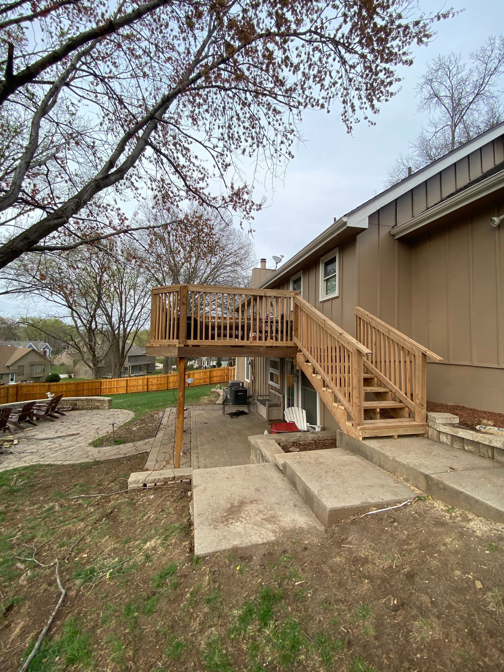 A house with a wooden deck and stairs in the backyard.