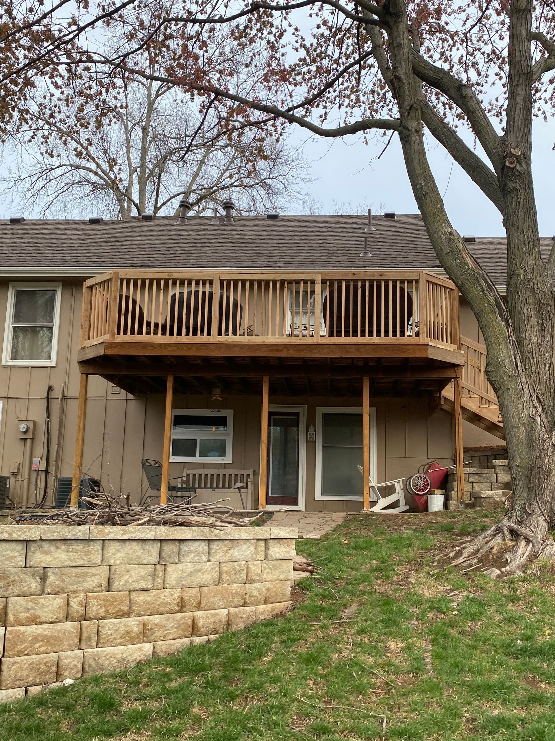A house with a large wooden deck on the back of it.