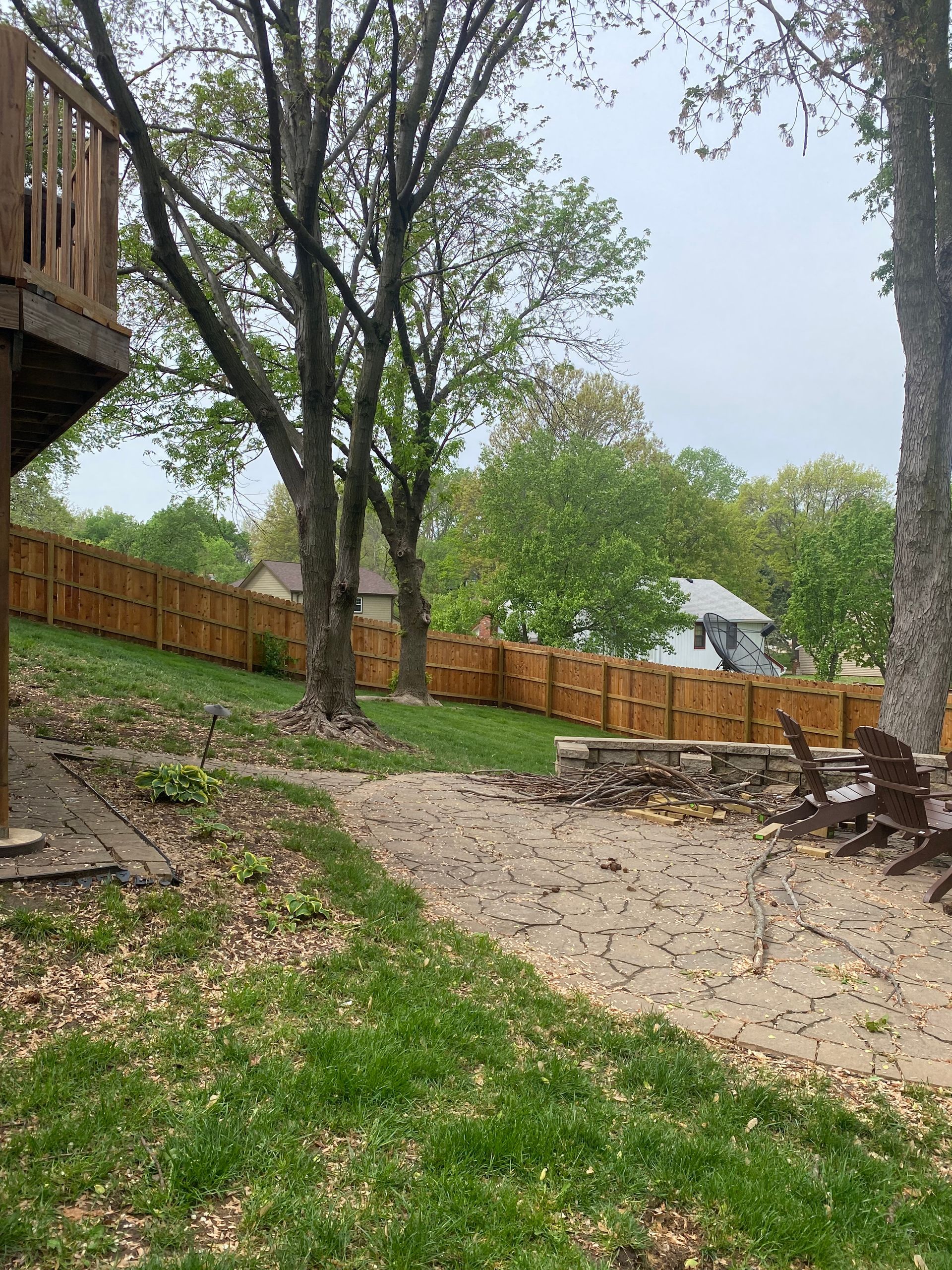 A backyard with a wooden fence and a deck.