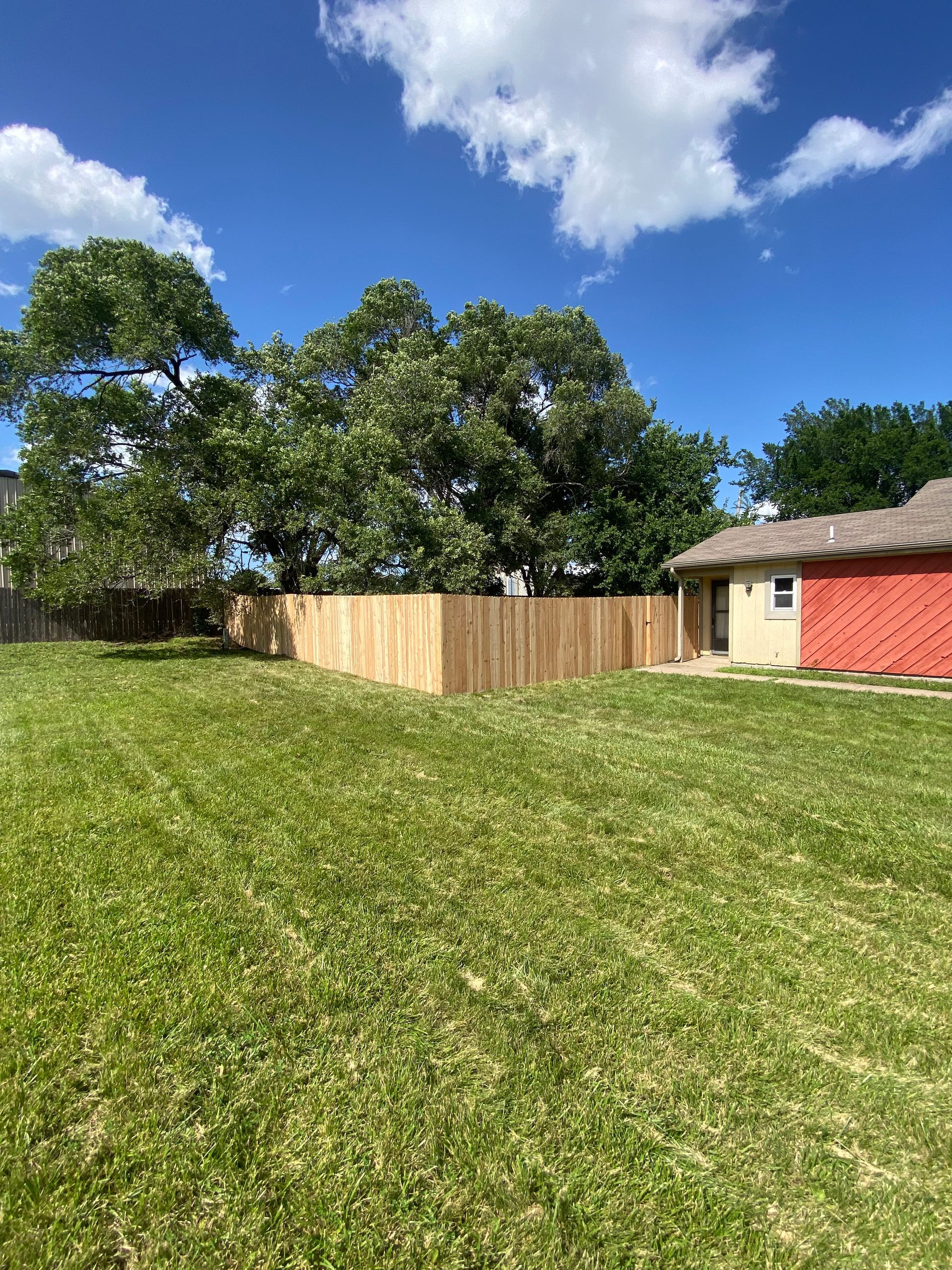 There is a wooden fence in the backyard of a house.