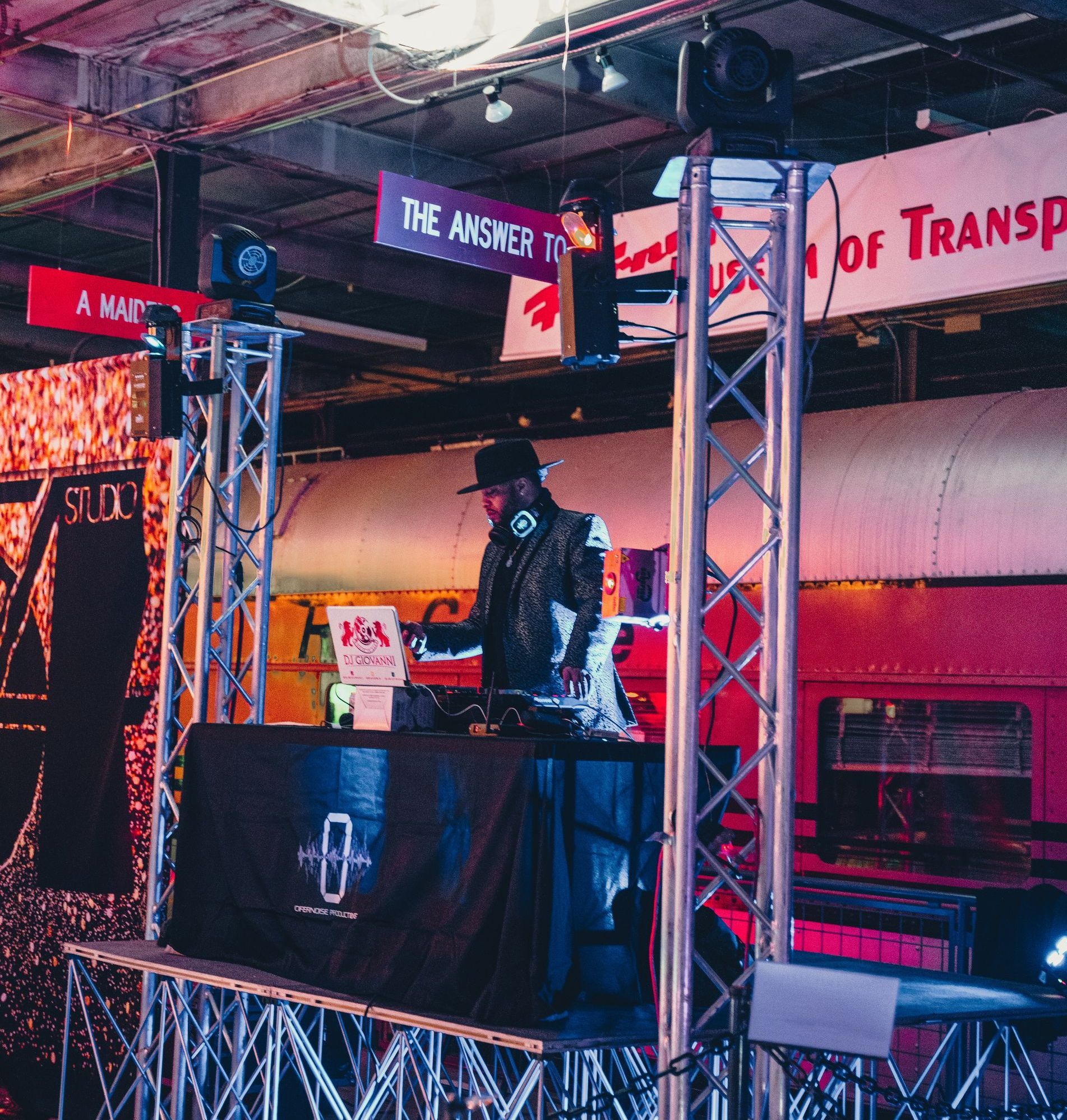 dj on a stage playing music at an event with lighting setup