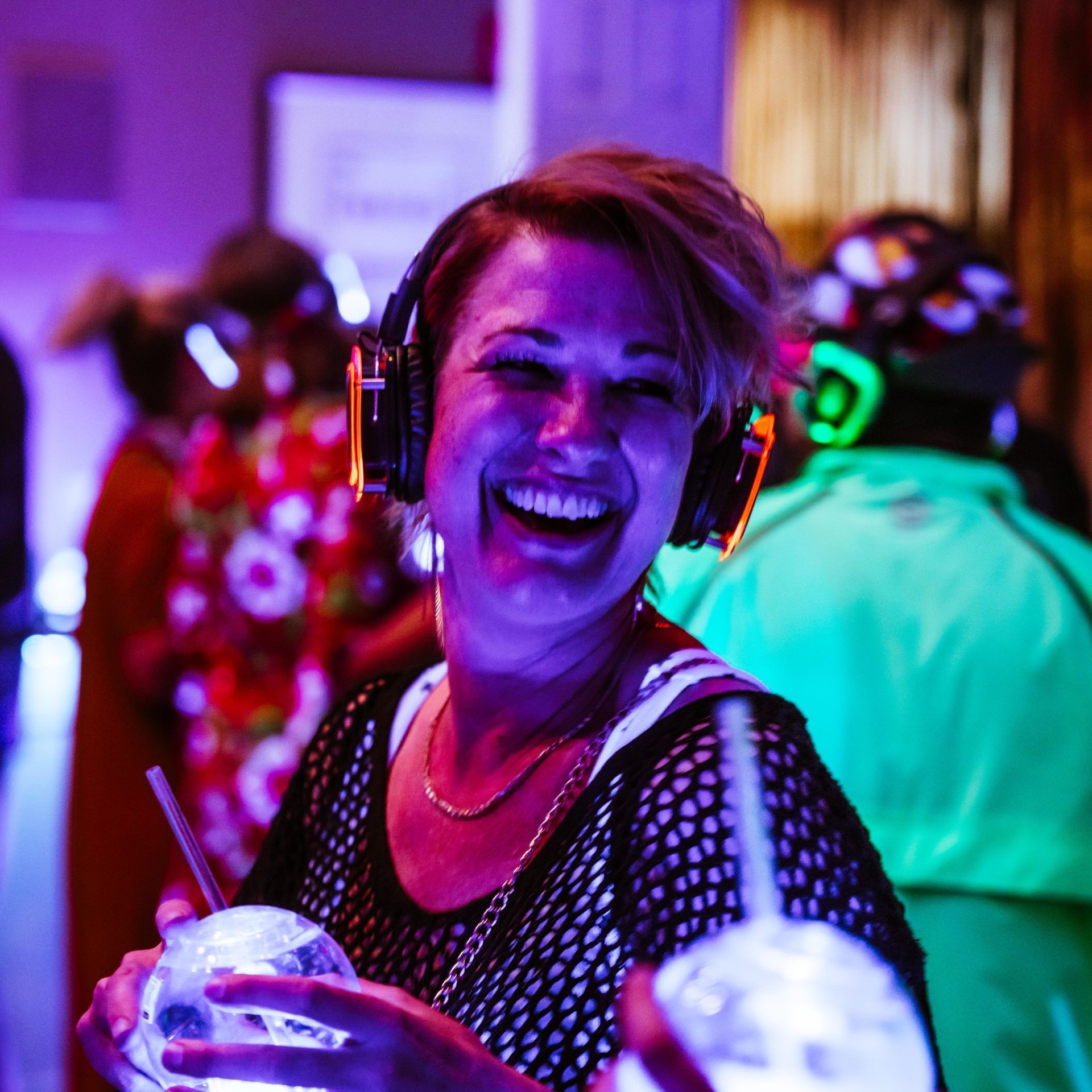 woman wearing silent disco headphones in a bar event with lights