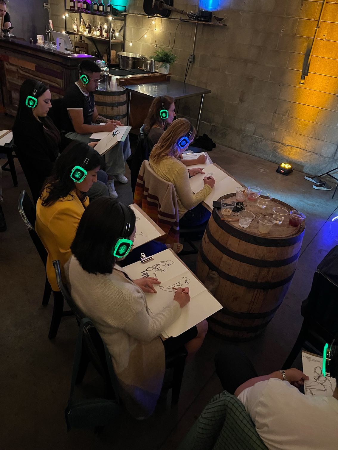 People sitting around drawing, listening through silent disco headphone