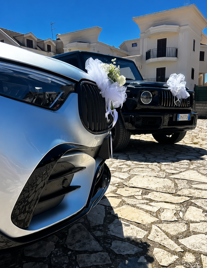 Due auto decorate nere e argento parcheggiate su un vialetto di pietra fuori da una villa