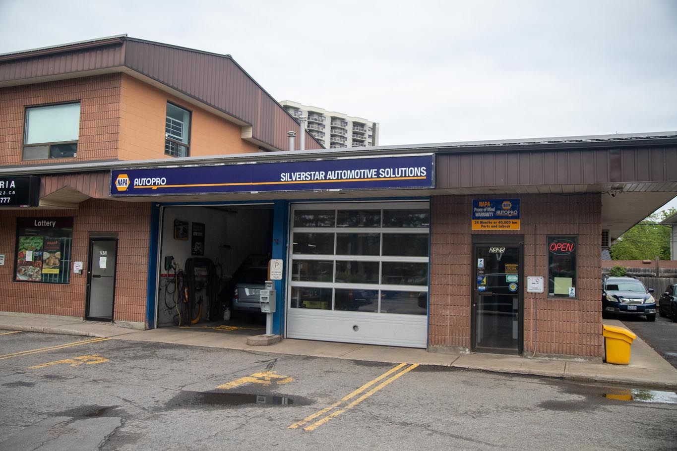 Automotive Solutions storefront with open garage bays and blue trim