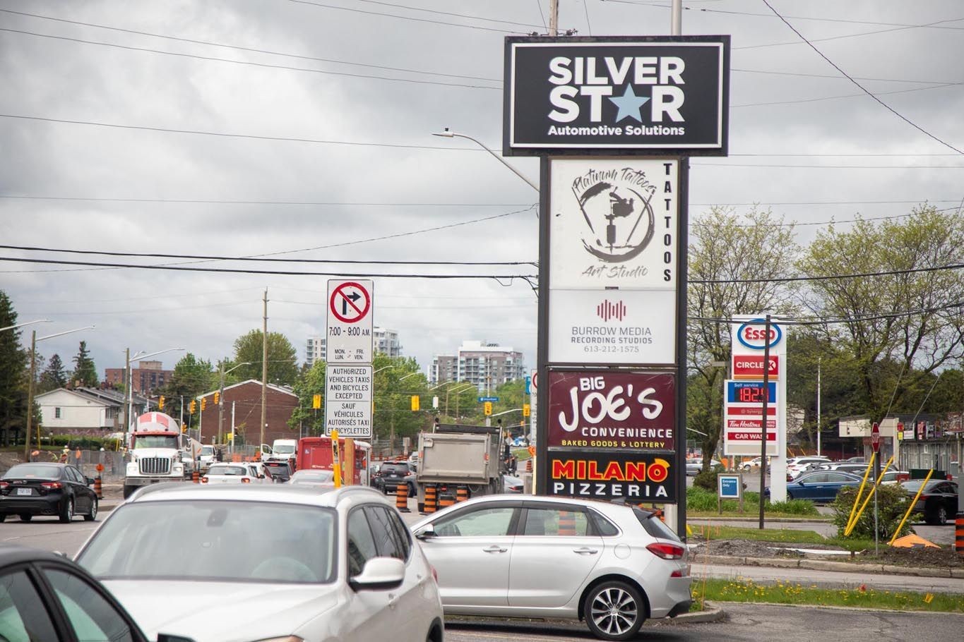 Rainy roadside with a Silver Star sign, storefronts, and cars at an intersection