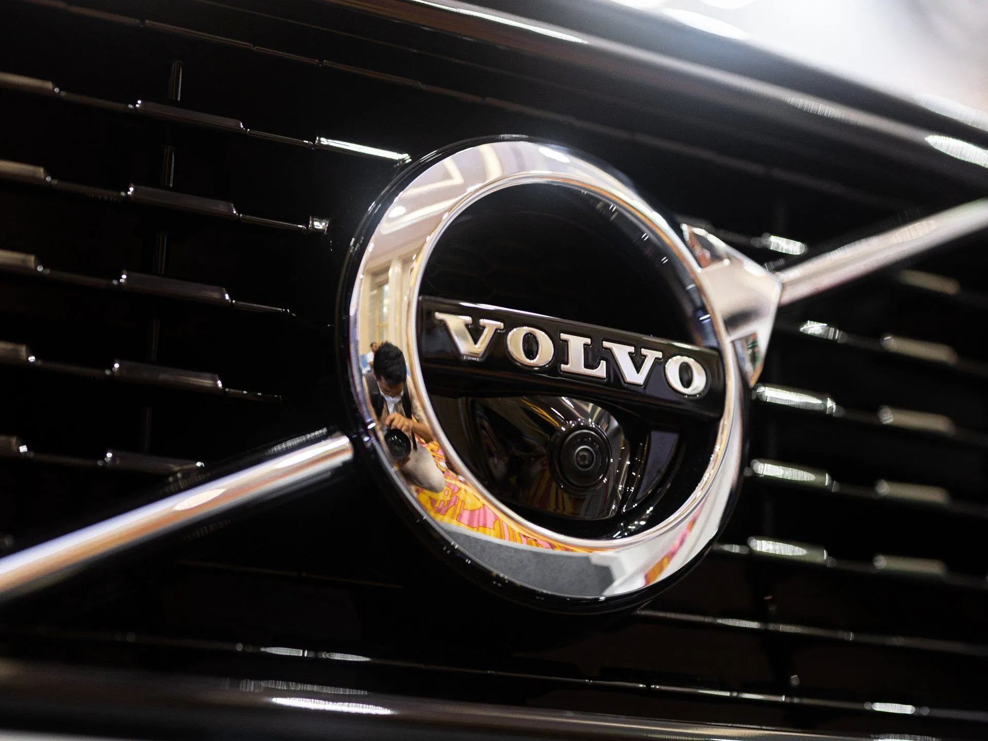 Close-up of a Volvo car grille badge with chrome emblem on a black grille