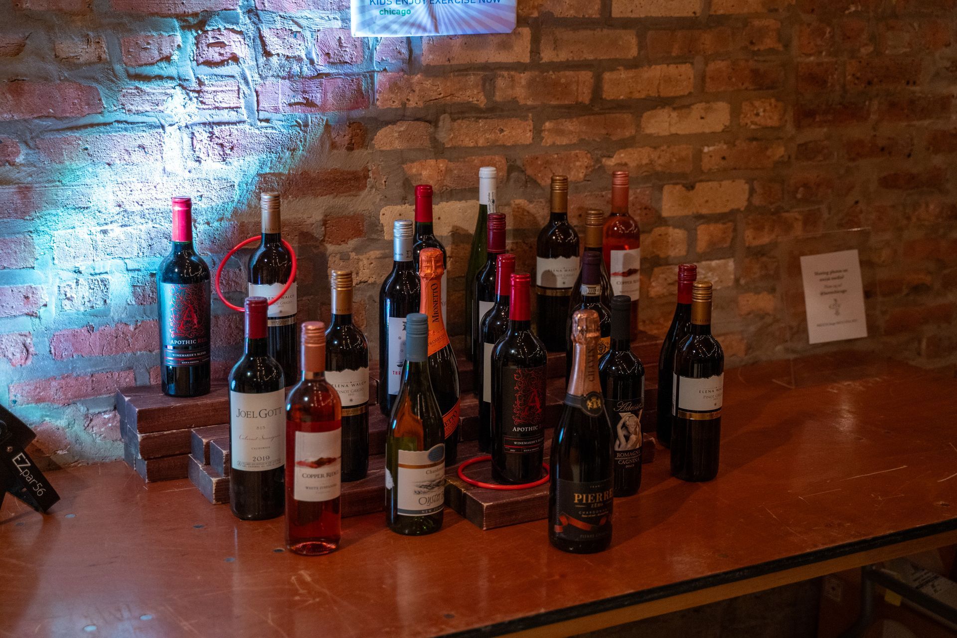 Wine bottles are lined up with a couple of rings around them after a round of wine toss is played.