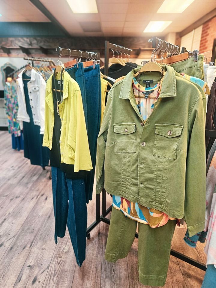 Clothing rack in a boutique with various outfits.
