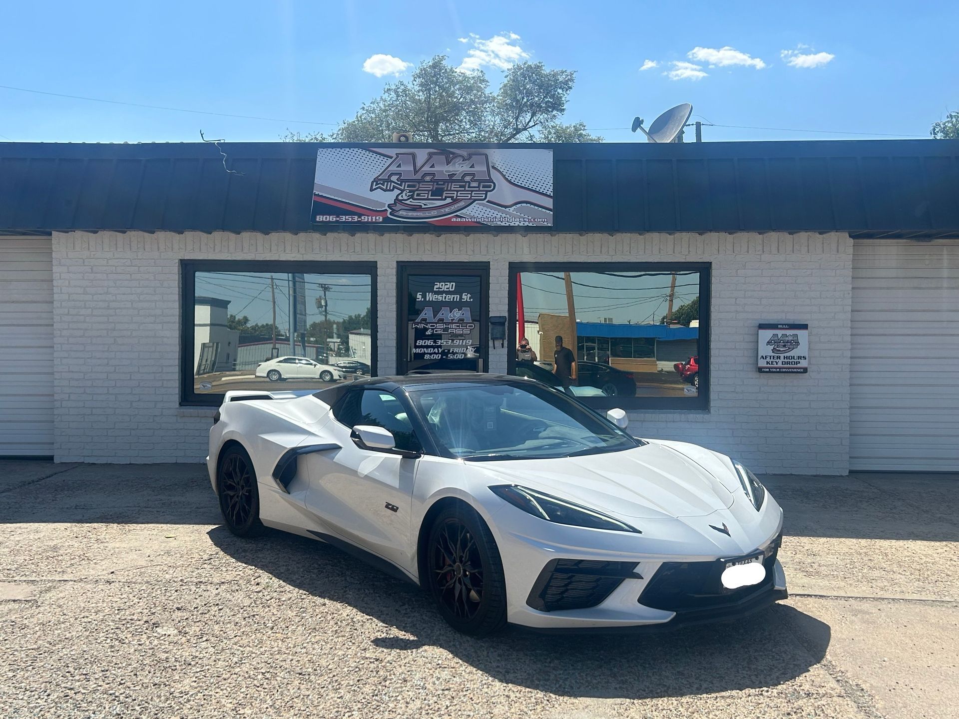 GEICO Auto Glass Repair Shop in Plainview, Lubbock, & Amarillo, TX White sports car parked in front of a small auto shop with a blue roof and large windows
