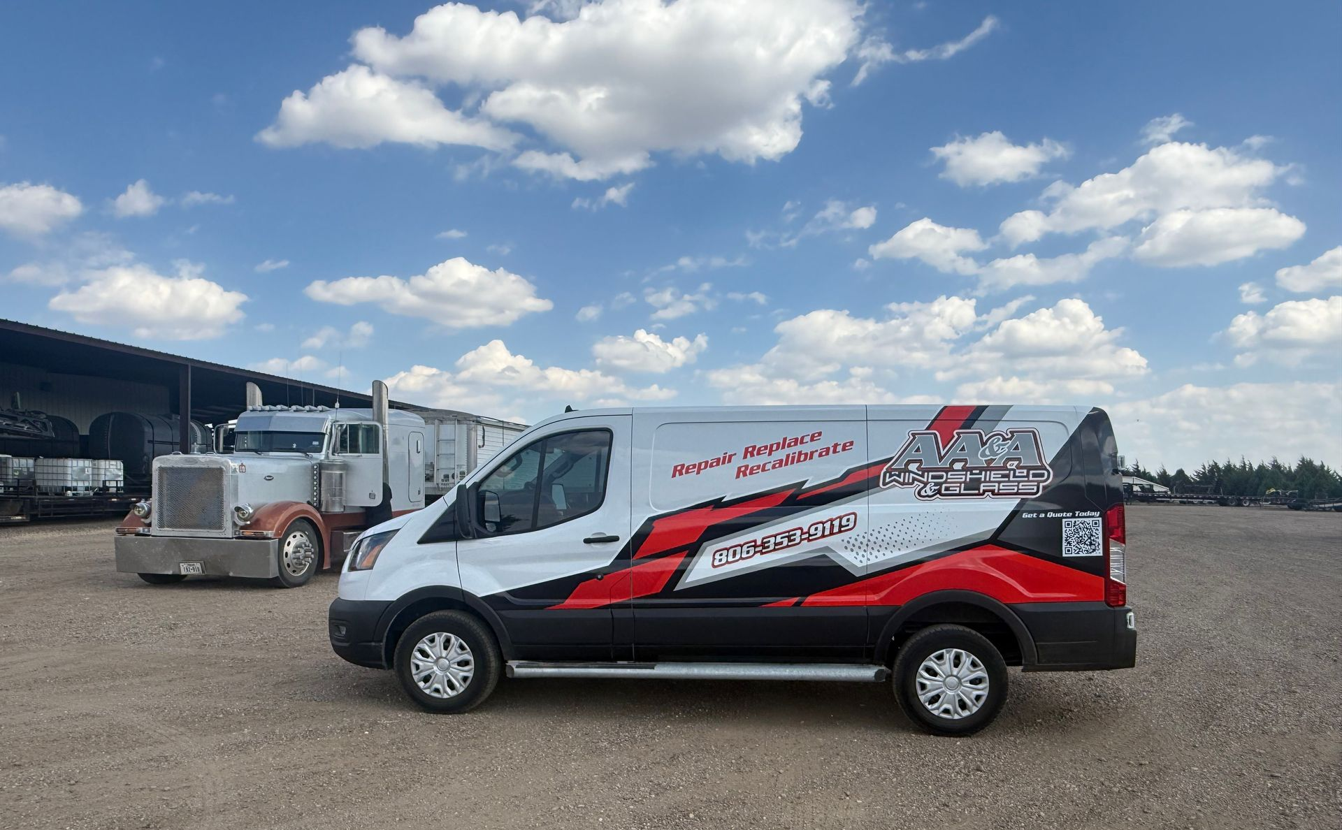 White and red van parked in an open lot under a cloudy blue sky, with trucks in the background