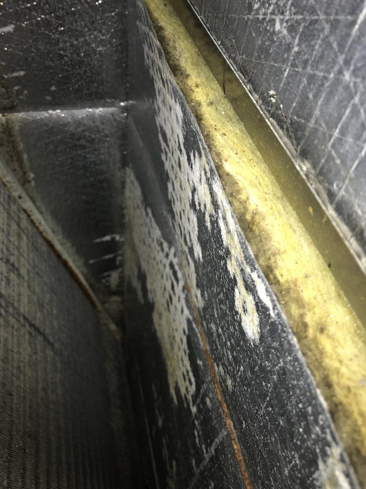 Close-up of a worn black and yellow metal surface with peeling paint and grime.