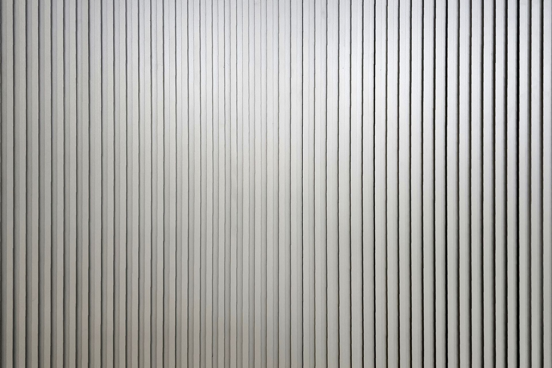 Vertical gray corrugated metal wall with narrow white stripes