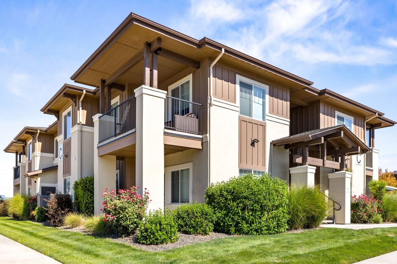 Two-story apartment building exterior with balconies and landscaped grounds at Olympus at Ten Mile, offering pet-friendly apartments in Meridian, ID.