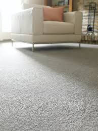 A white chair is sitting on a gray carpet in a living room.