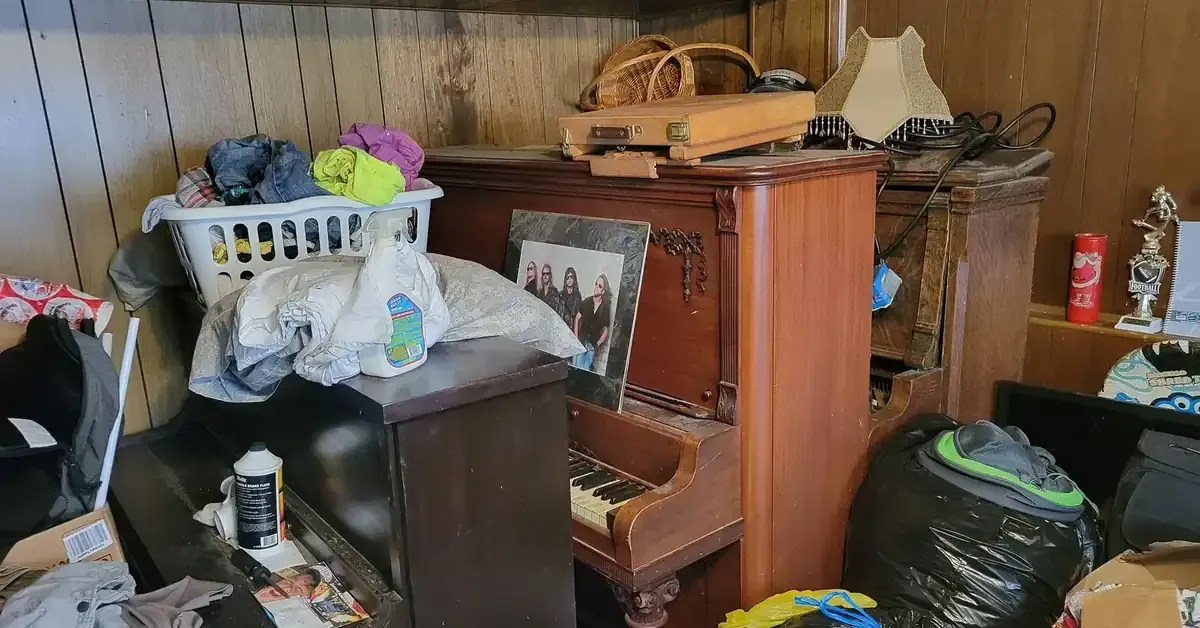 Cluttered room with piano and household items during an estate cleanout in Boardman, OH
