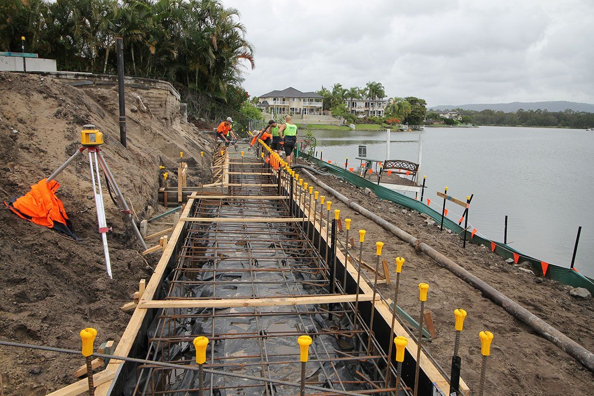 A bridge is being built next to a body of water.