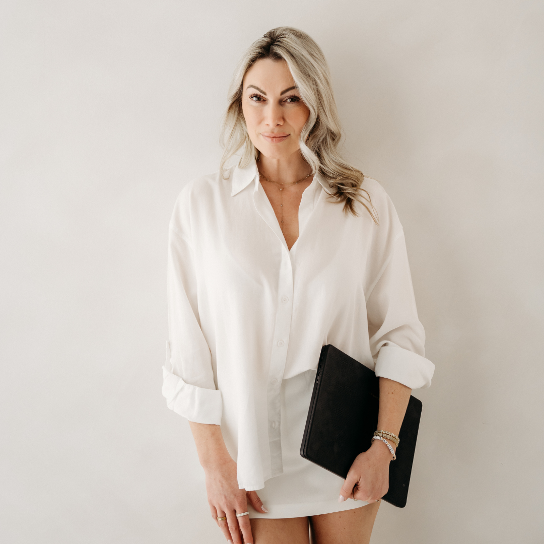 Woman in a white blouse holding a black laptop