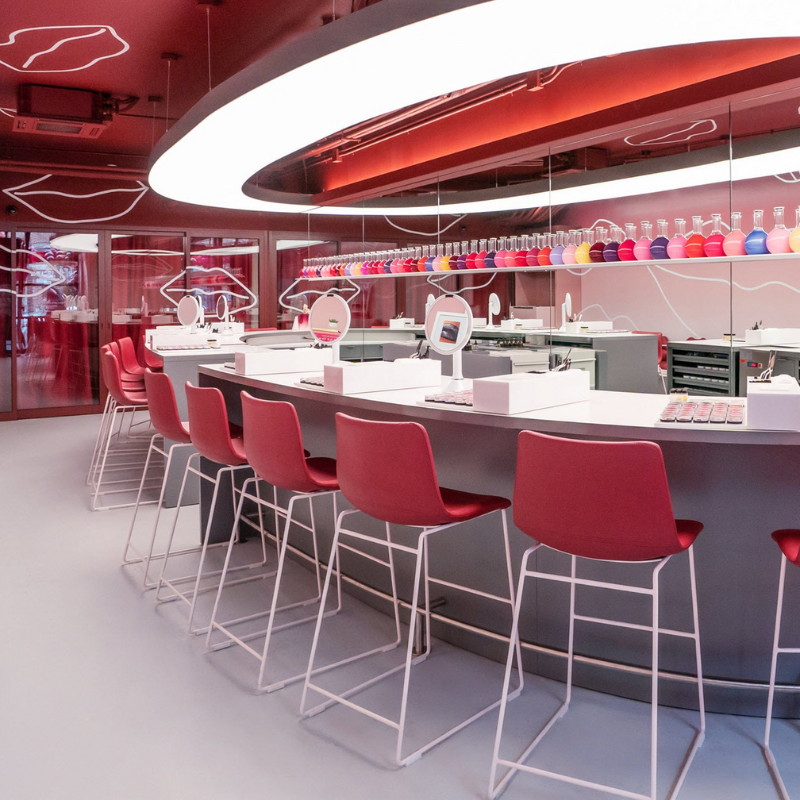 A row of red stools sitting along a long table