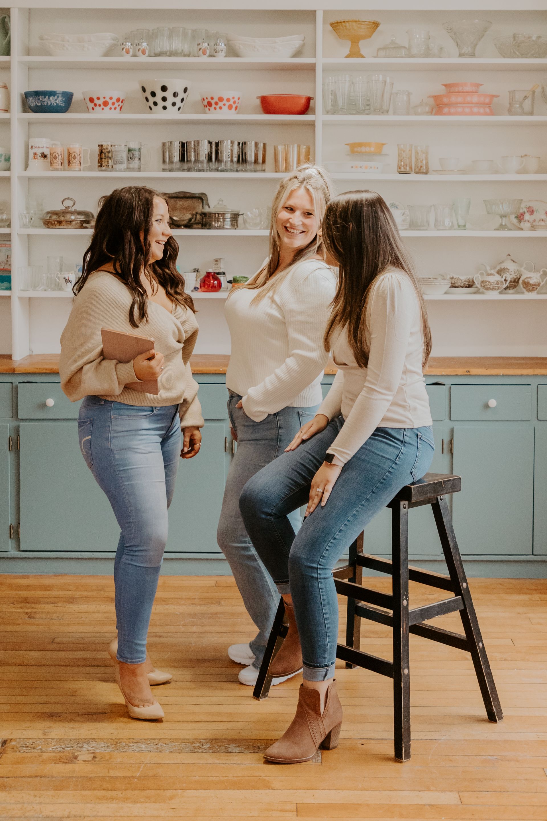 Three women standing next to each other in a kitchen