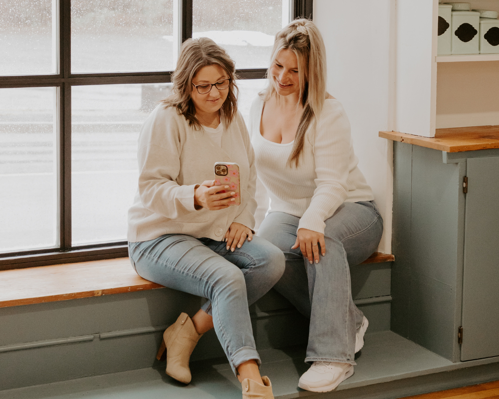 two marketers looking at social media content on cellphone