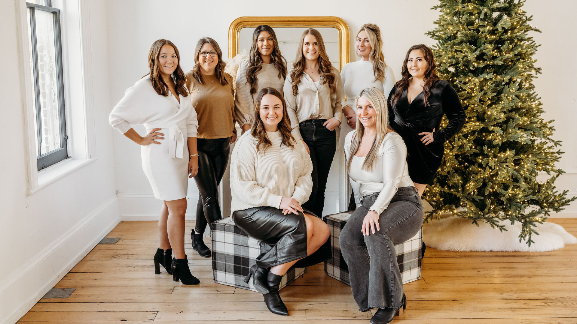 A group of women posing for a picture in front of a christmas tree