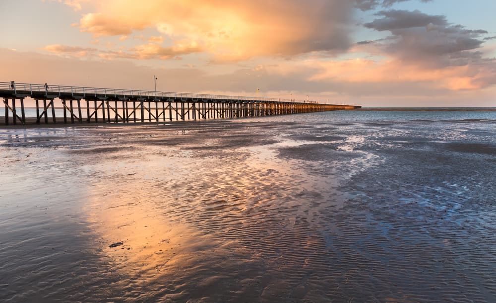 A Pier on a Beach at Sunset — Brett Negus Plumbing In Hervey Bay, QLD