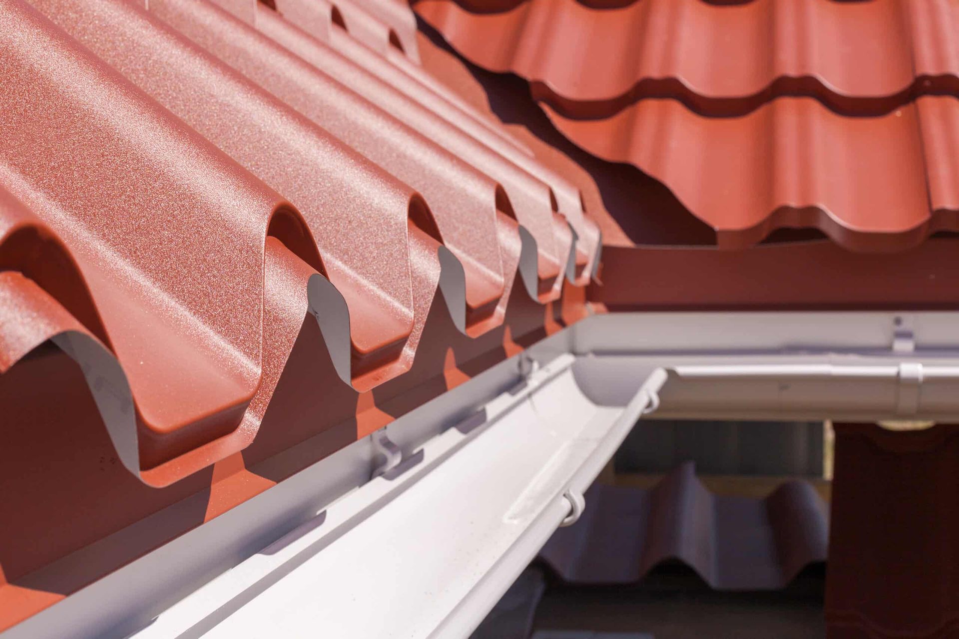 A Close Up of a Gutter on a Red Roof — Brett Negus Plumbing In Oakhurst, QLD