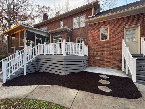 Brick building with a white accessibility ramp and stairs leading to the entrance
