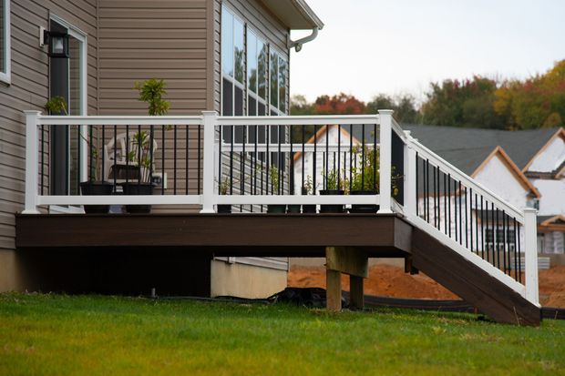 House deck with white railings and stairs overlooking a green lawn House deck with white railings and stairs overlooking a green lawn