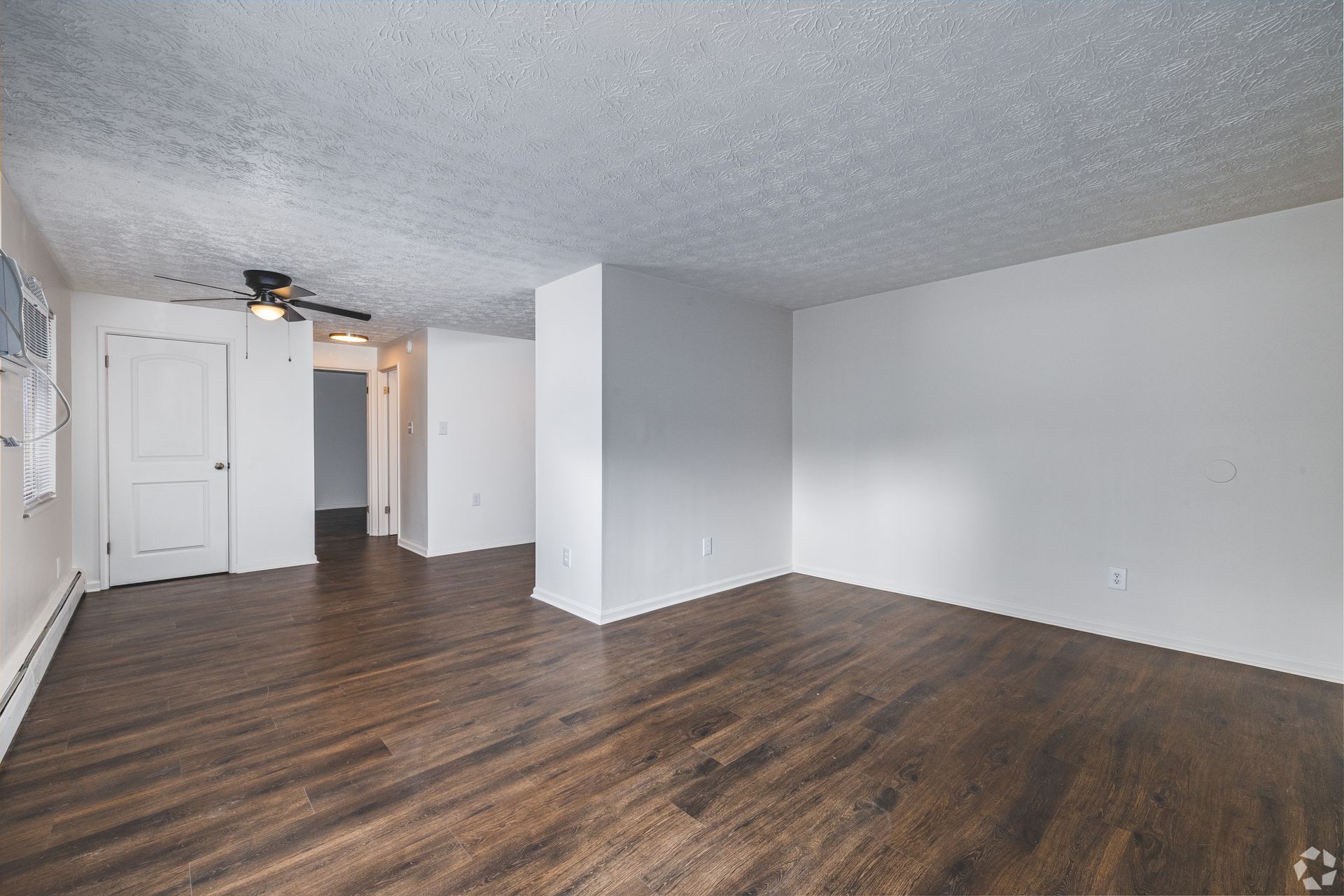 Spacious Overlook at Sunset living room with wood-style flooring, ceiling fan, and open layout.