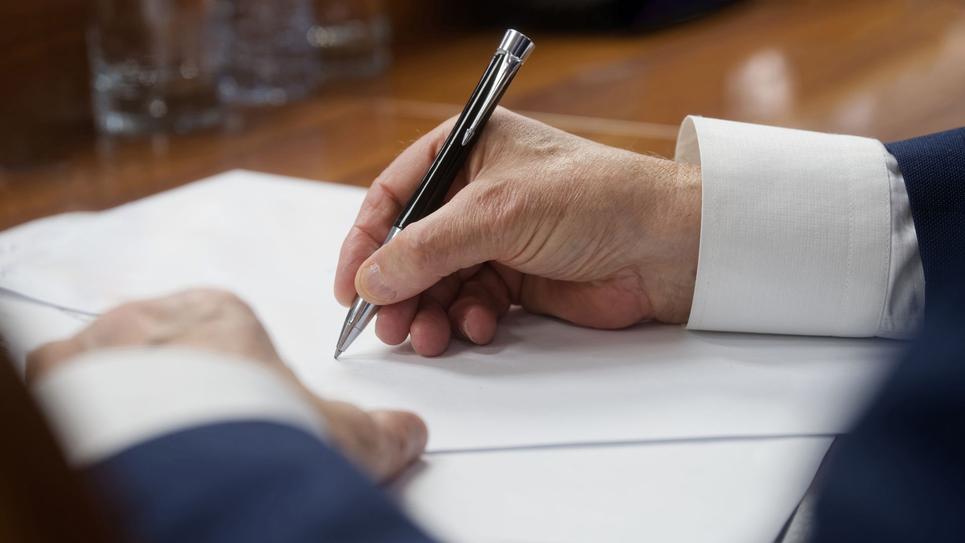 Attorney signing legal documents on a desk during a probate case. Attorney signing legal documents on a desk during a probate case.