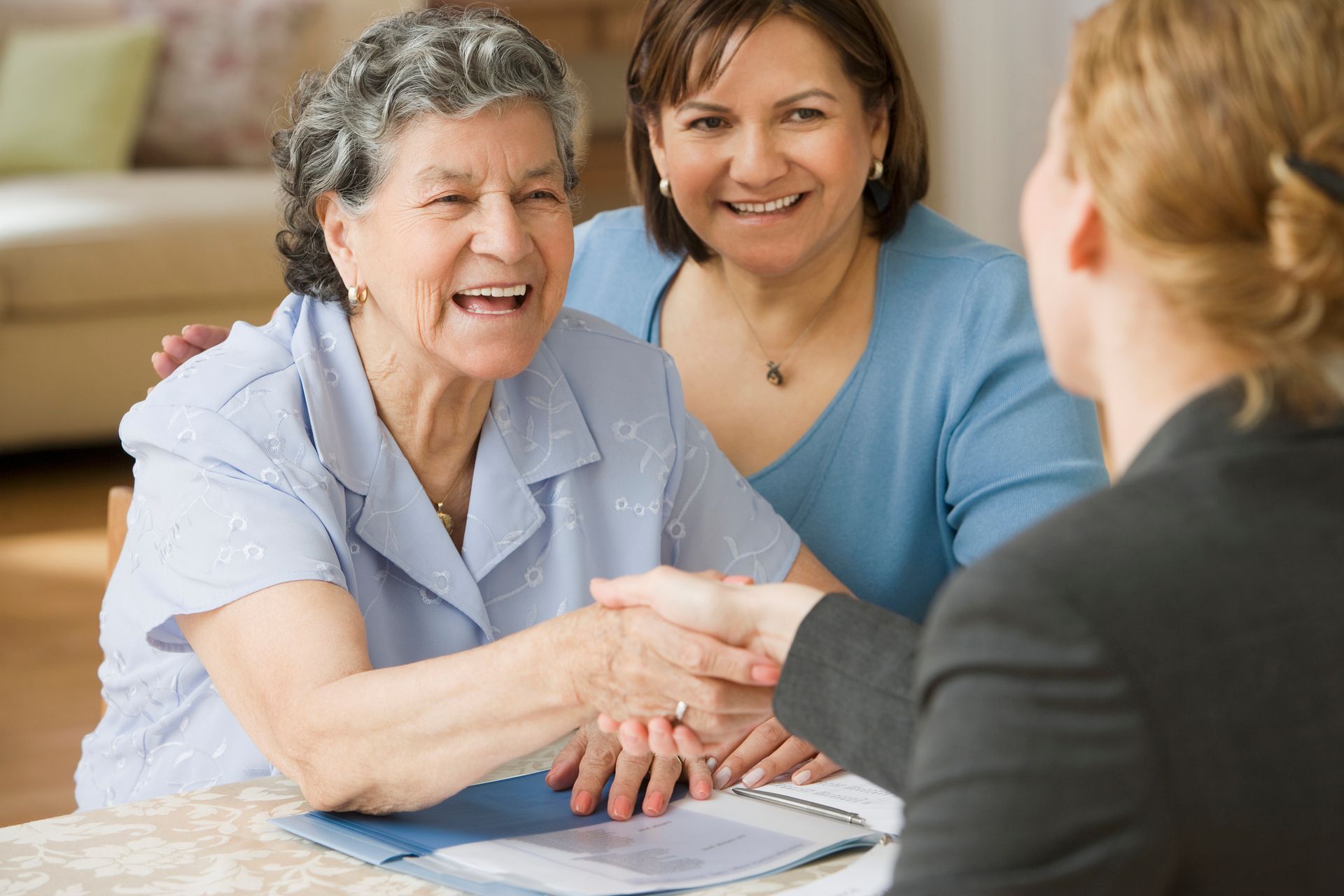 A senior woman is shaking a lawyer’s hand.