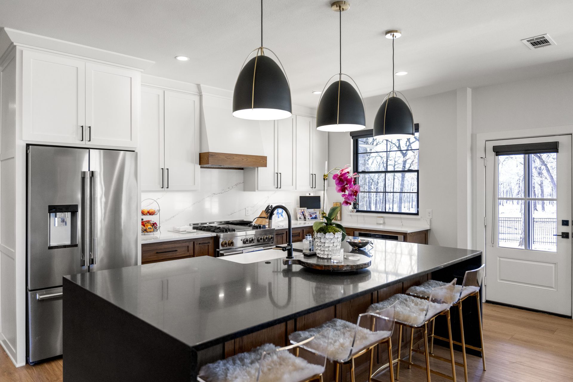 A kitchen with white cabinets , stainless steel appliances , and a large island.
